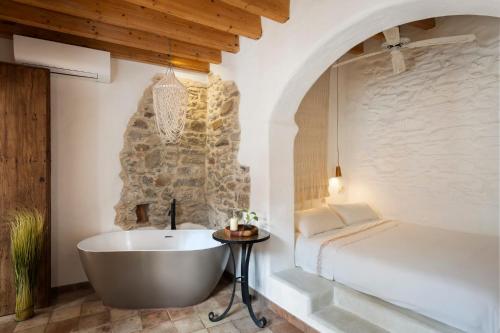 a bathroom with a bath tub next to a bed at Azogue Studios in Tarifa