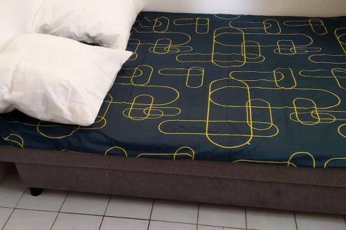 un lit avec un couvre-lit bleu et or et un oreiller dans l'établissement Petit studio rénové proche Place République 75011, à Paris