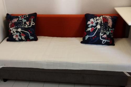 un lit avec deux oreillers dessus dans l'établissement Petit studio rénové proche Place République 75011, à Paris