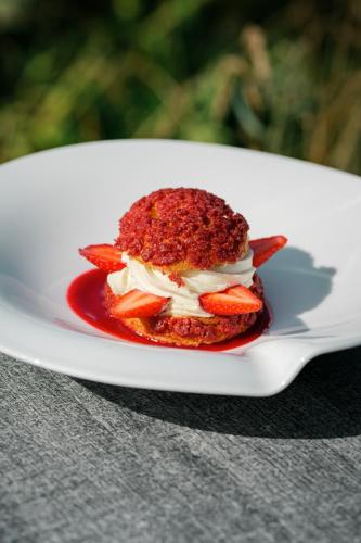 a piece of cake on a white plate with a fork at L'Esplanade Hôtel Restaurant Bar à vin in Le Pellerin