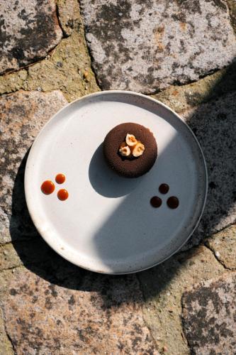a chocolate cookie on a plate on the ground at L'Esplanade Hôtel Restaurant Bar à vin in Le Pellerin