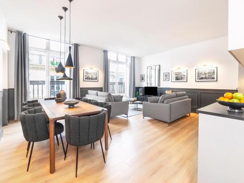 une cuisine et un salon avec une table et des chaises dans l'établissement LivinParis Luxury AC 3 Bedrooms Le Louvre II, à Paris