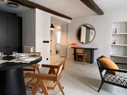 - un salon avec une table, des chaises et un miroir dans l'établissement Au Vieux Bassin, à Honfleur