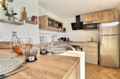 - une cuisine avec une table en bois et des verres dans l'établissement Magnificent T3 apartment with balcony and parking - Sainte-Foy-lès-Lyon, à Sainte-Foy-lès-Lyon