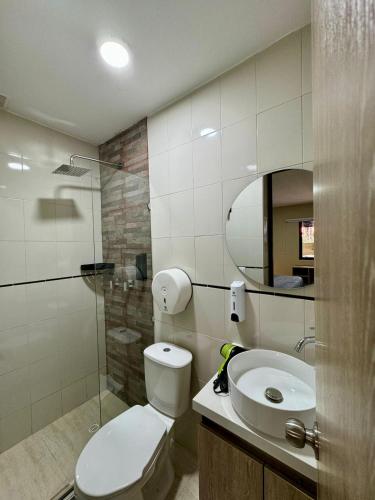 a bathroom with a toilet and a sink and a mirror at Hostelfc Usaquen in Bogotá