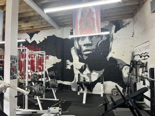 a gym with a wall with a mural of a man at Modern Cozy City Centre Double Suite - Fast WiFi, Free Gym Access in Leicester