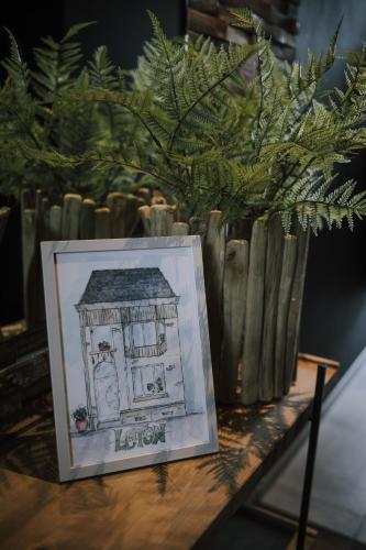 a drawing of a house on a table next to a vase at Vakantiewoning Leton in Brakel