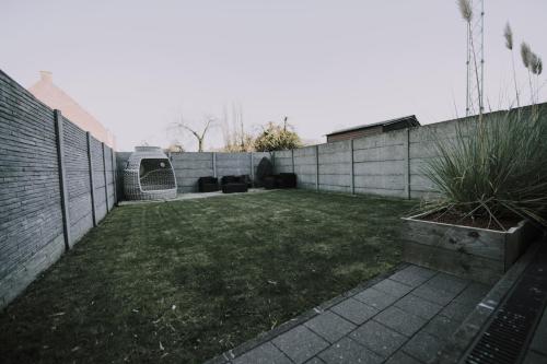 a backyard with a fence and a grass yard at Vakantiewoning Leton in Brakel