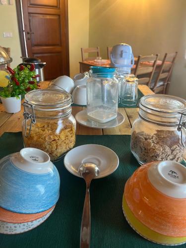 a wooden table with jars of food and a spoon at Il Casale di David in Pontedera