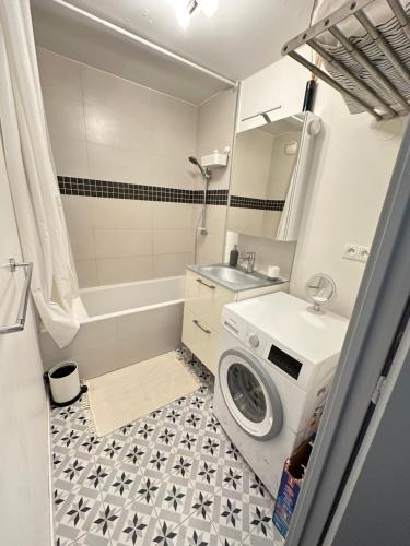 W łazience znajduje się pralka i umywalka. w obiekcie Cosy Duplex avec Parking à Paris 19 by immo kit bnb w Paryżu