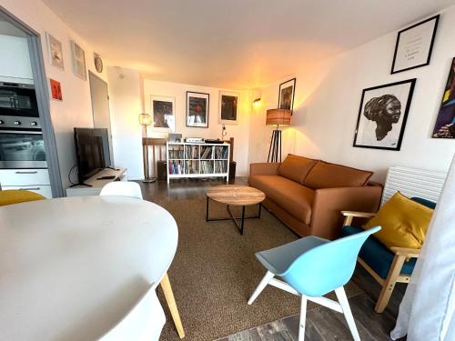 un salon avec un canapé et une table dans l'établissement Cosy Duplex avec Parking à Paris 19 by immo kit bnb, à Paris