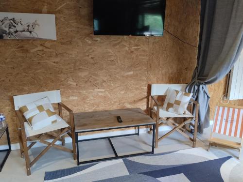 a living room with two chairs and a table at Studio Cosy Boxes Chevaux en sus in Agnez-lès-Duisans
