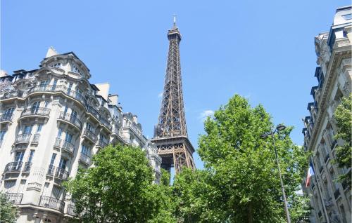 - une vue sur la tour Eiffel entre deux bâtiments dans l'établissement Lovely Apartment In Paris With Kitchen, à Paris