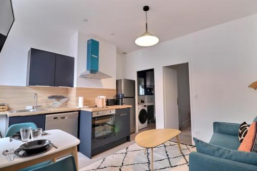 une cuisine et un salon avec un canapé et une table dans l'établissement The Cocoon - Studio-Apartment - Villeurbanne, à Villeurbanne