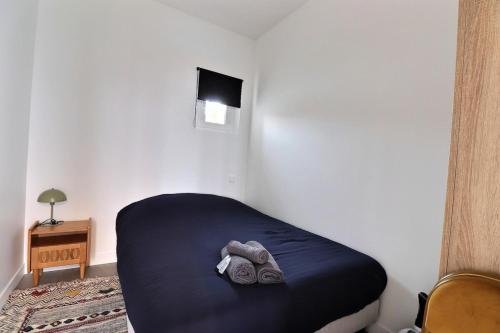 Cette petite chambre comprend un lit avec une couverture bleue. dans l'établissement The Cocoon - Studio-Apartment - Villeurbanne, à Villeurbanne
