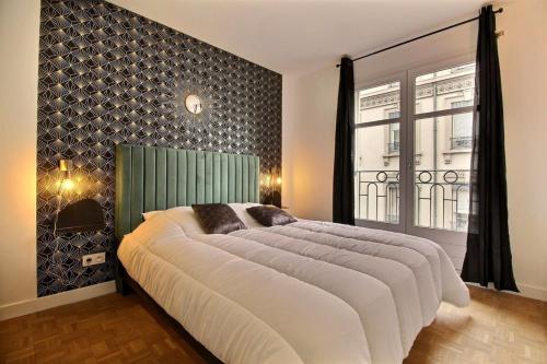 une chambre avec un grand lit et une fenêtre dans l'établissement Le Tropical - Beautiful apartment - Lyon 7th, à Lyon