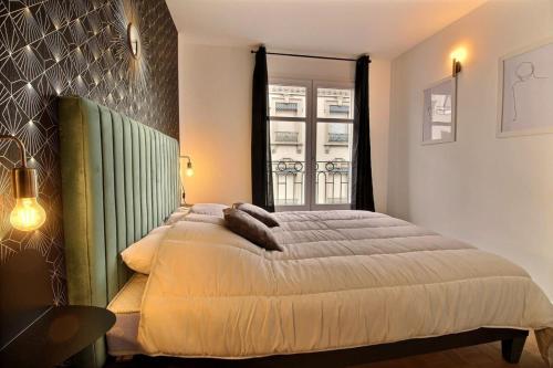 une chambre avec un grand lit et une fenêtre dans l'établissement Le Tropical - Beautiful apartment - Lyon 7th, à Lyon