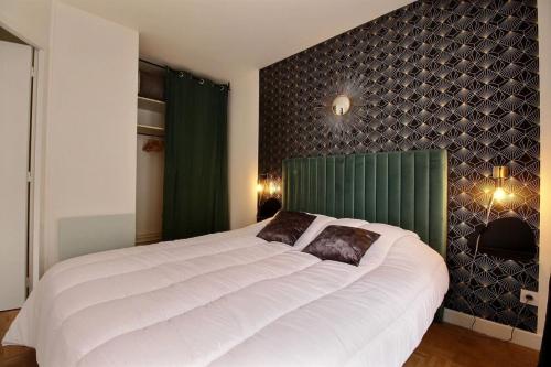 - une chambre avec un grand lit blanc et une tête de lit verte dans l'établissement Le Tropical - Beautiful apartment - Lyon 7th, à Lyon