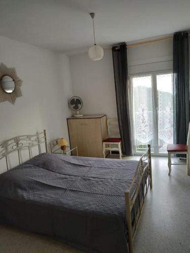 une chambre avec un grand lit avec une couverture bleue dans l'établissement Appartement Climatisé avec Vue Mer et Montagne, à Banyuls-sur-Mer