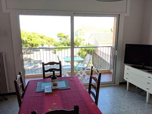 Cette chambre dispose d'une grande fenêtre et d'une table avec des chaises. dans l'établissement Appartement Climatisé avec Vue Mer et Montagne, à Banyuls-sur-Mer