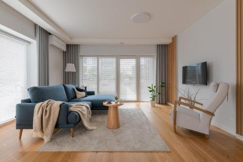 a living room with a blue couch and a table at D33 Vilnius - Brand New Luxury Apartment with Terrace, Garden, AC and Parking in Vilnius