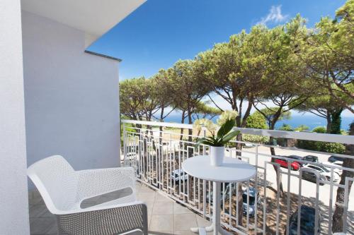 a balcony with a table and chairs and trees at Hotel O Sole Mio in SantʼAgata sui Due Golfi