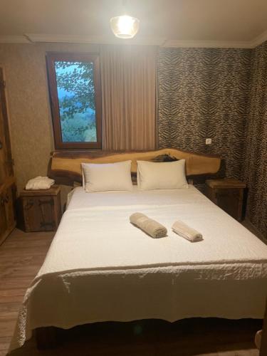 une chambre avec un grand lit avec deux serviettes dessus dans l'établissement Guest house and cellar MAMULI, à Tʼerjola