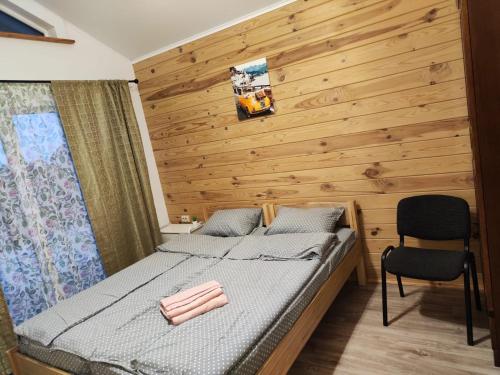 a bedroom with a bed and a wooden wall at Дом Дискавери семейный у моря! in Chornomorsk