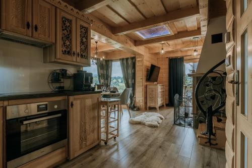 a kitchen with wooden cabinets and a living room at Zacisze Galicove in Zakopane