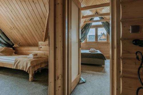 a bedroom with a bed in a wooden house at Zacisze Galicove in Zakopane