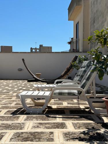 two white lounge chairs sitting on top of a roof at B&B Palazzo Giordano Luxury Rooms in Squinzano