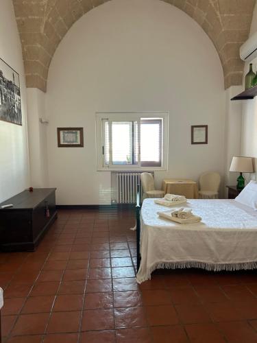 a room with a bed and a table and chairs at B&B Palazzo Giordano Luxury Rooms in Squinzano