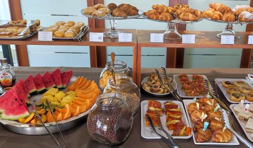 een tafel met verschillende soorten levensmiddelen op borden bij Hotel Colonna in Lido di Jesolo