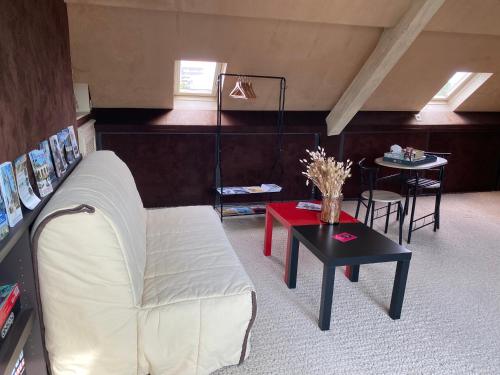 a living room with a couch and a table at La chambre de Mathilde in Caen