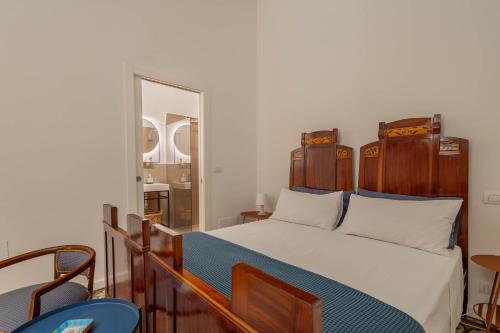 1 dormitorio con 1 cama con cabecero de madera y espejo en AI PALMENTI B&B, en Adelfia