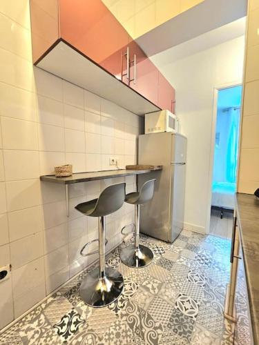 - une cuisine avec deux tabourets de bar et un réfrigérateur dans l'établissement Appartement en bords de Seine proche de Paris, à Alfortville