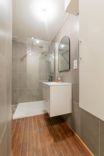 une salle de bain avec un lavabo blanc et une douche dans l'établissement Appart spacieux 4 chambres , Clim au cœur de Nîmes MaisonCarréeConciergerie, à Nîmes