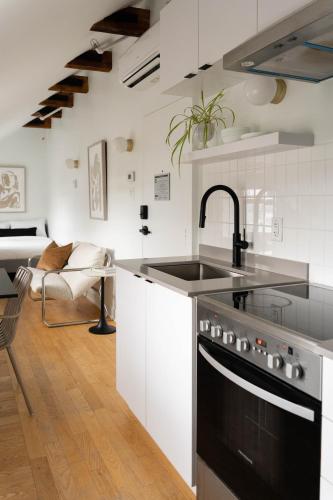 a kitchen with a sink and a stove top oven at Maison Rasco by Luxury In Transit in Montréal