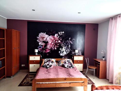 a bedroom with a bed with a painting on the wall at Apartament Dolek in Szczawnica