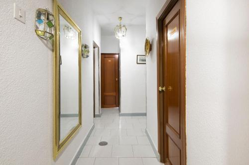 a hallway with a mirror on the wall and a door at Pension Mesones in Granada