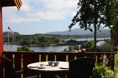 a table on a balcony with a view of a river at Åkviktunet hytte nord in Averoy