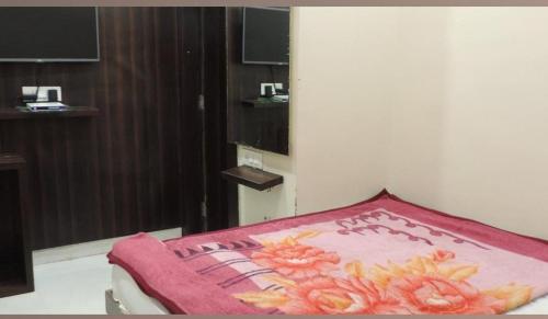 a bed with a pink blanket on top of it at Hotel Paradise Stays in Pachmarhī