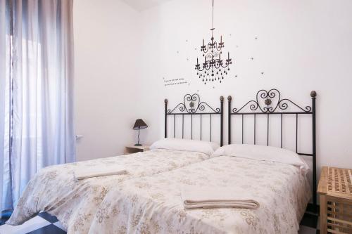 a bedroom with a large bed with a chandelier at Pension Mesones in Granada
