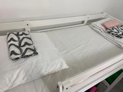 un lit blanc avec deux oreillers dessus dans l'établissement Petit studio rénové à la place Comédie, à Montpellier