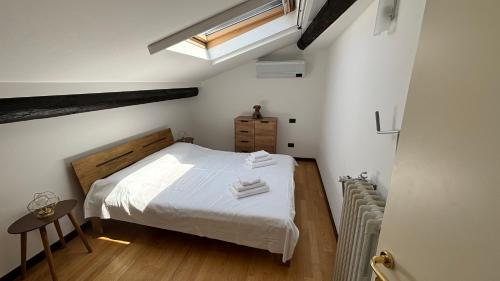 una camera con letto bianco e lucernario di Casa Angela Apartments a Bergamo