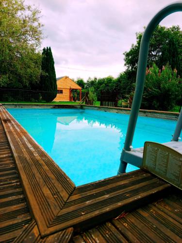 une balançoire en face d'une piscine dans l'établissement Bungalow 2 pièces, SDB, terrasse, Piscine de mai à octobre, à Gauville