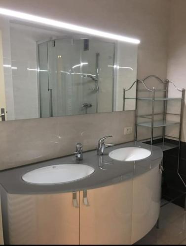 une salle de bain avec deux lavabos et un grand miroir dans l'établissement Bright 70m2 2-room apartment,garden,facing the sea, à Menton