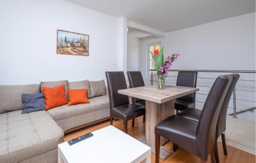 a living room with a couch and a table with chairs at Amazing Apartment In Premantura in Premantura