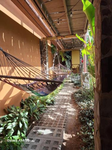 a hammock hanging from the side of a building at Hotel Iris Arenal in Fortuna