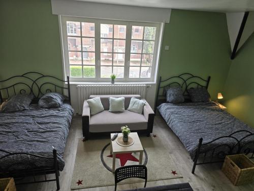 une chambre avec deux lits et un canapé et une fenêtre dans l'établissement chambre villa, à Waziers